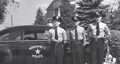 Two years later, two more policemen (including Ed Clapper, center) joined John Aman (right), who was named chief of police. They shared one squad car, and worked out of cramped quarters at Village Hall until Northfield built a new wing to house its force in 1968.